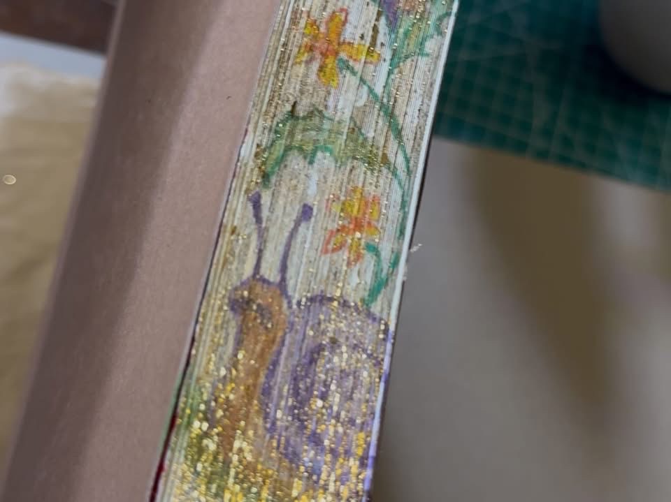Hidden watercolor fore-edge painting visible on the page edge