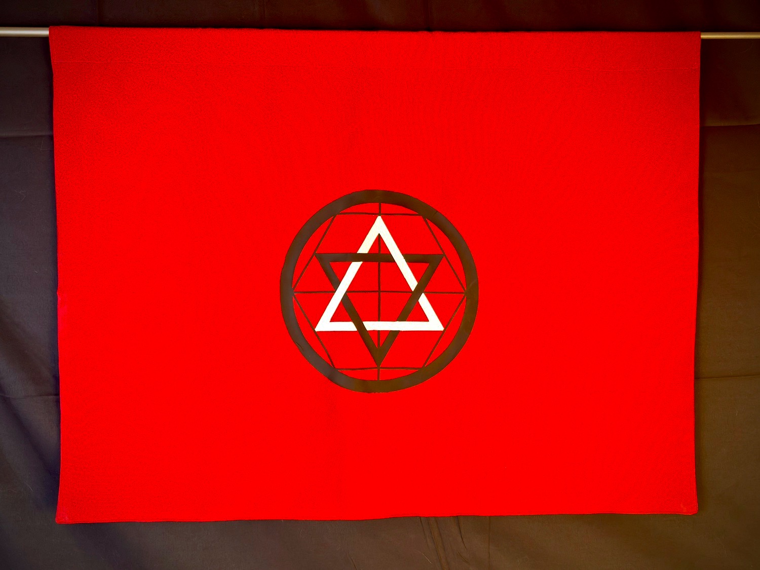 Horizontal Martinist banner in deep red 100% poplin with black and white interlocking triangle emblem inside a geometric circle.