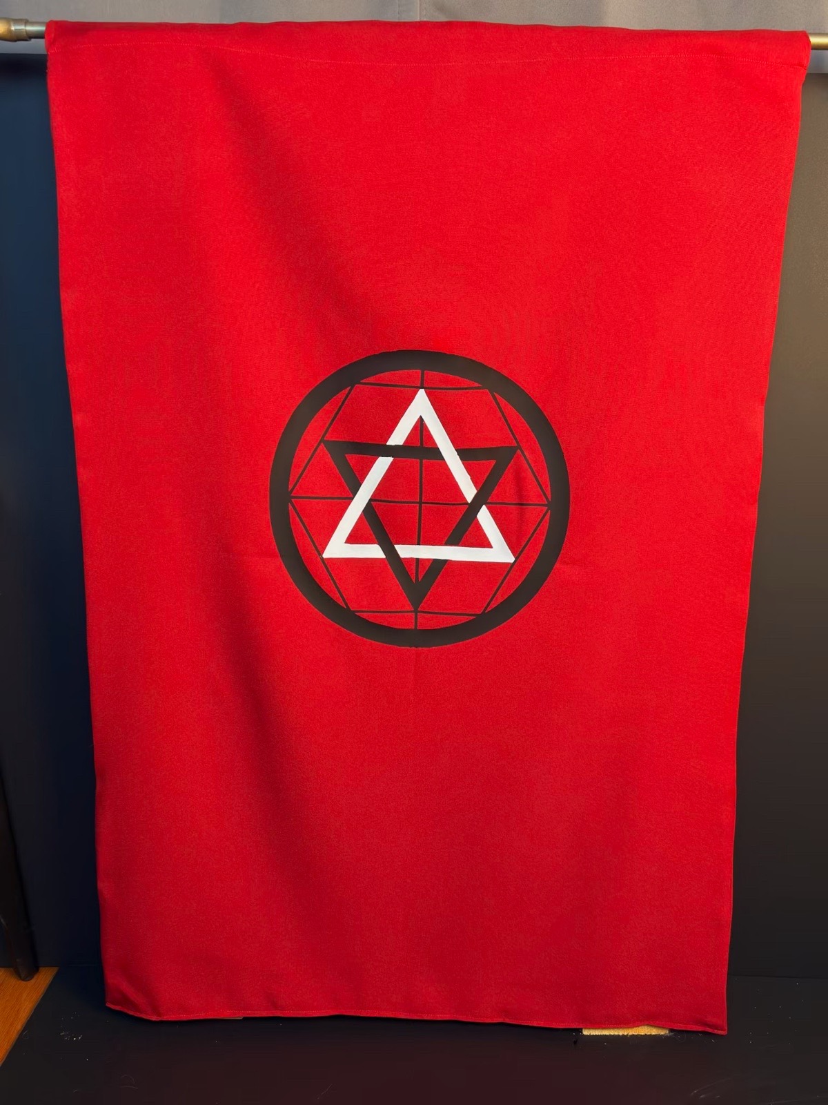 Martinist Banner full view — interlocking triangles within a geometric circle, black and white on a deep red field