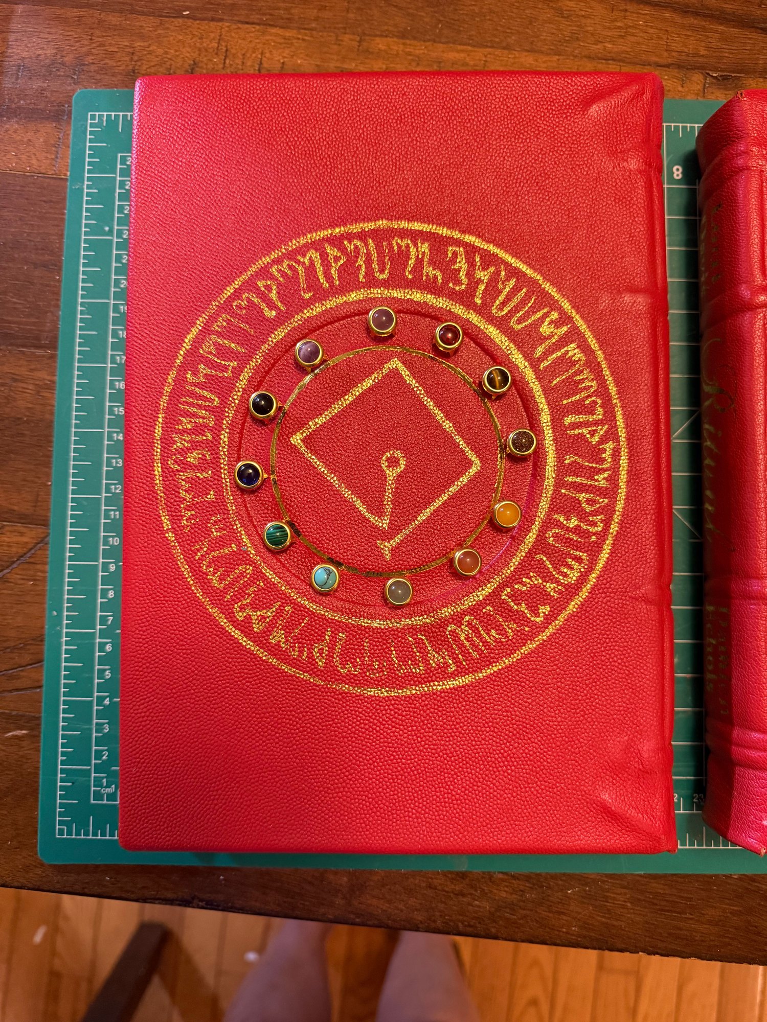 Back board of the hand-bound edition of Ritual — the sigil tooled in gold inside a ring of lettering on red goatskin