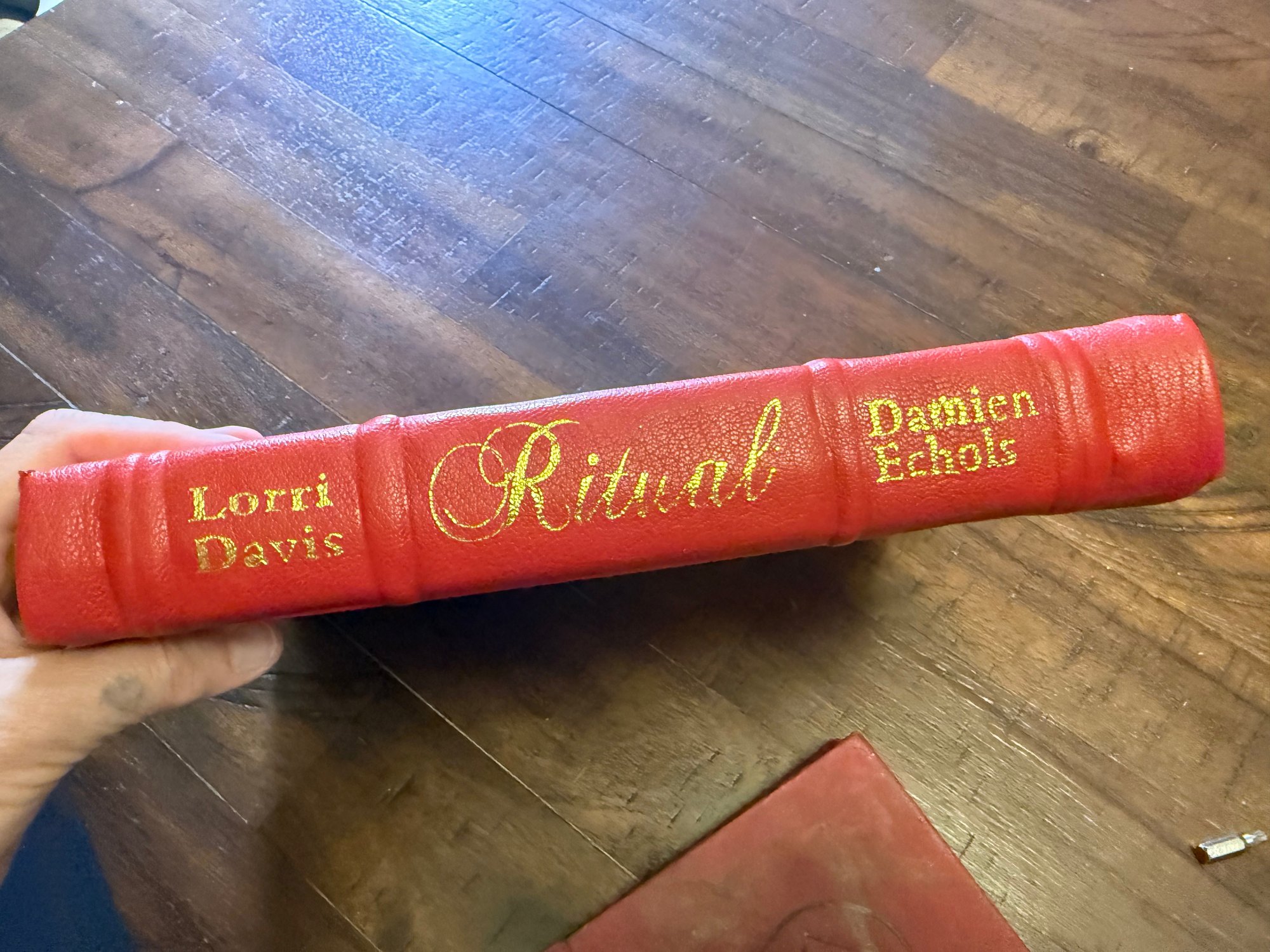 Spine of the hand-bound edition of Ritual — raised bands with the title and the authors' names tooled in gold on red goatskin